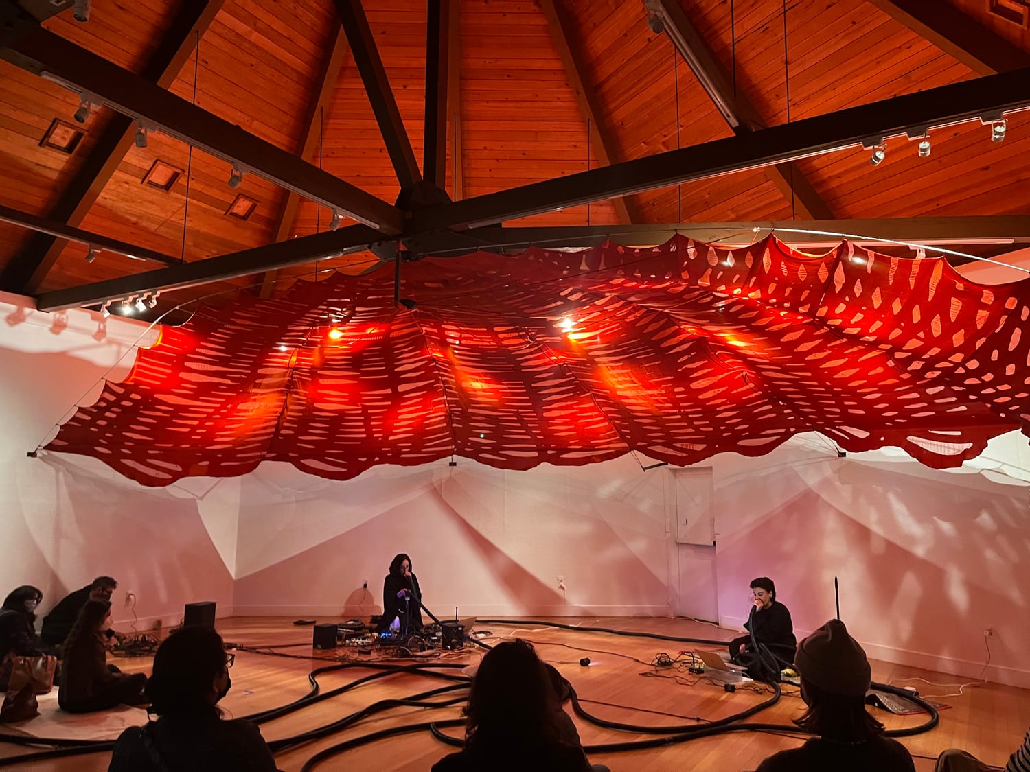 The red canopy of Crossings / عبور seen across the domed room during performance