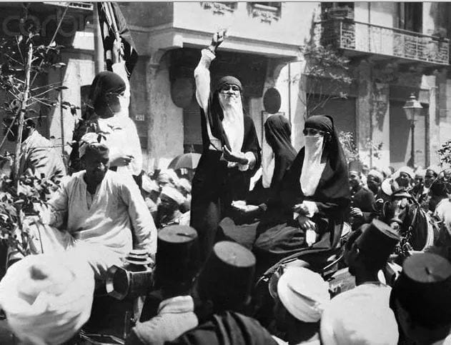 Archival photograph of Egyptian feminist Huda Shaarawi amid a 1919 revolutionary crowd — referenced in This Stays Between Us